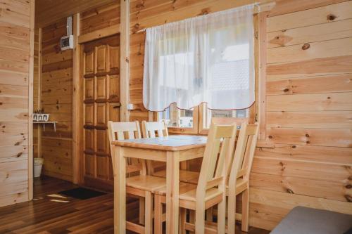 a dining room with a table and chairs in a cabin at Ranczo Tropical Sun Mielenko in Mielenko