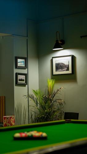 a green pool table in a room with a plant at Sort By Stays, Grand Peddem, Anjuna in Goa