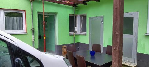 a green house with a table and chairs and a car at Ferienwohnung für bis zu 10 Personen in Koetz 