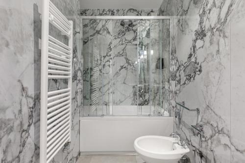 a bathroom with a toilet and a tub and a sink at Room Mate Luca, Florence in Florence