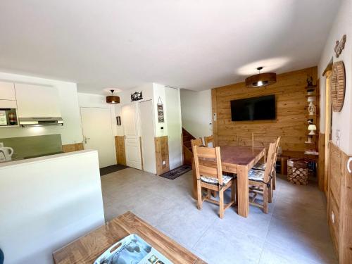 une cuisine et une salle à manger avec une table et des chaises dans l'établissement Appartement neuf sur les pistes avec parking et wifi - FR-1-505-190, à Notre-Dame-de-Bellecombe