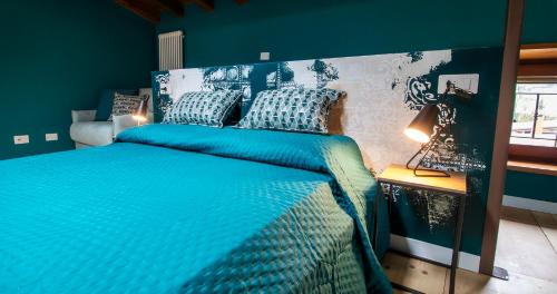 a blue bedroom with a large bed with blue sheets at BOSSEMA 8 Home in Calmasino