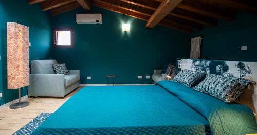 a blue bedroom with a large bed and a couch at BOSSEMA 8 Home in Calmasino