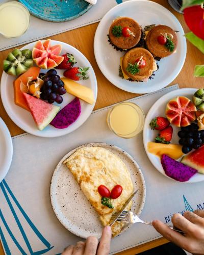 a table topped with plates of fruit and pies at Buzios Mar Hotel in Búzios