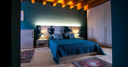 a bedroom with a bed with a blue bedspread at BOSSEMA 8 Home in Calmasino