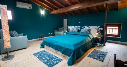 a blue bedroom with a bed and a couch at BOSSEMA 8 Home in Calmasino