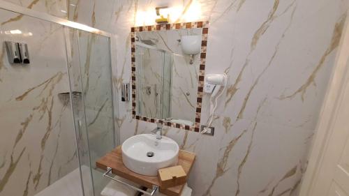 a bathroom with a sink and a shower with a mirror at AuRoom in Naples