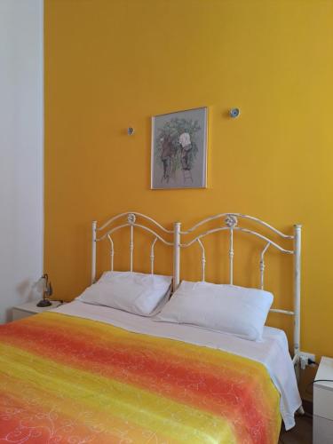 Un dormitorio con una cama con una manta colorida encima. en Casa Meraki - Appartamento in centro, en Avola
