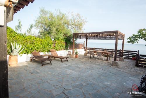 a patio with a gazebo and a table and chairs at Sea Side House in Nea Chili