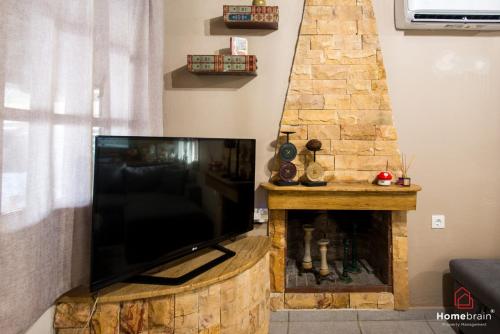 a flat screen tv sitting on top of a stone fireplace at Sea Side House in Nea Chili