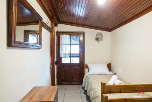 a bedroom with a bed and a wooden ceiling at Sea Side House in Nea Chili