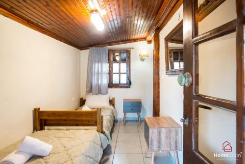 a bedroom with two beds and a wooden ceiling at Sea Side House in Nea Chili