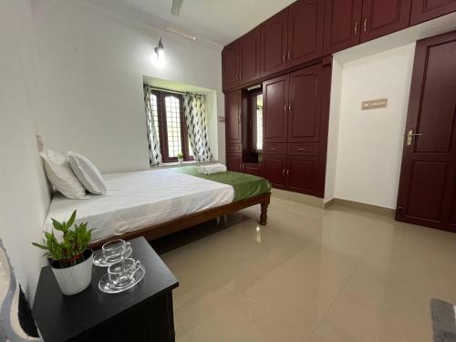 a bedroom with a large bed with a green seat at Halcyon Homes-Trivandrum in Chacka