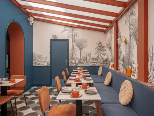 une grande salle à manger avec des tables et des chaises dans l'établissement Hôtel Biskui, à Levallois-Perret