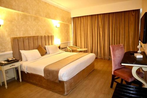 Habitación de hotel con cama grande y escritorio. en Paradise Inn Beach Resort en Alexandría
