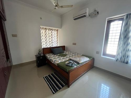 a bedroom with a bed in a room at Halcyon Homes-Trivandrum in Chacka