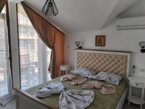 a bedroom with a large bed with a large window at Стаи за гости Гергана град Созопол in Sozopol