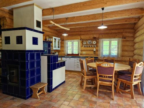 a kitchen with a table and chairs and a stove at Relax Srub Kunějov in Hosterschlag