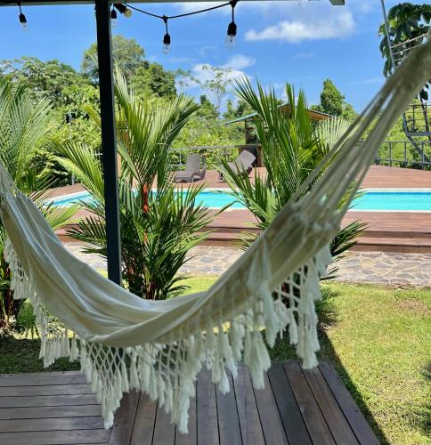 a hammock on a deck with a pool at Southern Drake Lodge in Drake