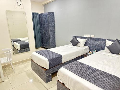 a hotel room with two beds and a mirror at Hotel Aerotel,Hyderabad in Shamshabad