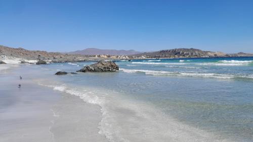 a beach with rocks in the water and the ocean at HERMOSO DEPTO COND MARINA SOL Lado CASINO ENJOY in Coquimbo