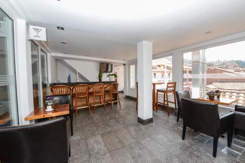 a dining room with chairs and tables and a bar at Hotel Plaza de Armas Cusco in Cusco