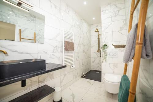 Baño blanco con lavabo y aseo en Lovely Apartment Palace of Versailles, en Versalles