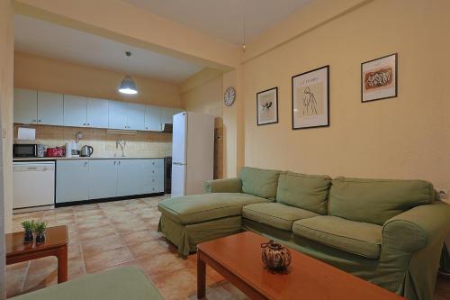Una sala de estar con un sofá y una cocina. en Paralia Comfort House, en Paralia Katerinis