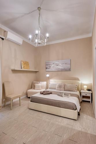 a bedroom with two beds and a chandelier at Your House Rooms in Genova