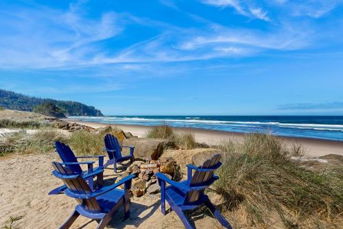 three blue chairs sitting on a beach near the ocean at Pacific Dream in Neskowin
