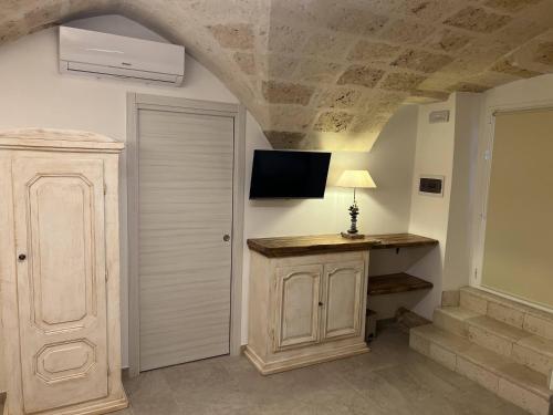 a room with a table and a tv on the wall at La Valigia sul letto in Mesagne