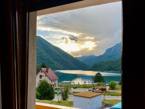 a view of a lake and mountains from a window at Apartment LAKEVIEW in Plužine