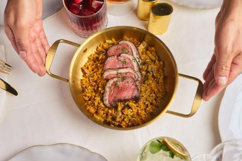 a pan filled with meat and rice on a table at Presidente InterContinental Mexico City by IHG in Mexico City
