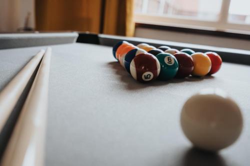 a line of cue balls on a pool table at Comfy 3BR Home - Pool Table - Games - Sleeps 8 in Manchester