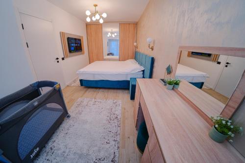 una piccola stanza con due letti e una televisione di AtmoSphere Apartment by Infinity Resort & Spa a Mamaia Nord - Năvodari