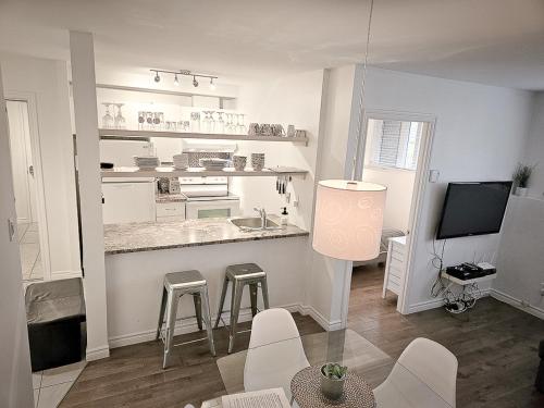 a kitchen with a counter and stools in a room at Le 4 SAISONS 1 in Beaupré