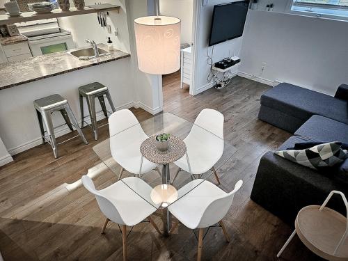 a living room with white chairs and a table at Le 4 SAISONS 1 in Beaupré