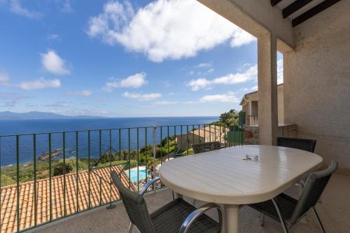 a table on a balcony with a view of the ocean at Residence Roc E Mare Cargèse in Cargèse