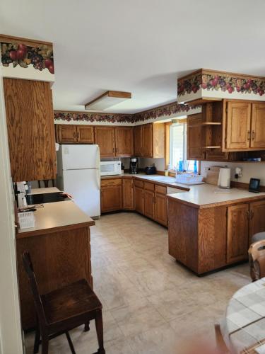 Una cocina con gabinetes de madera y un refrigerador blanco. en The Legacy Home, en Midland