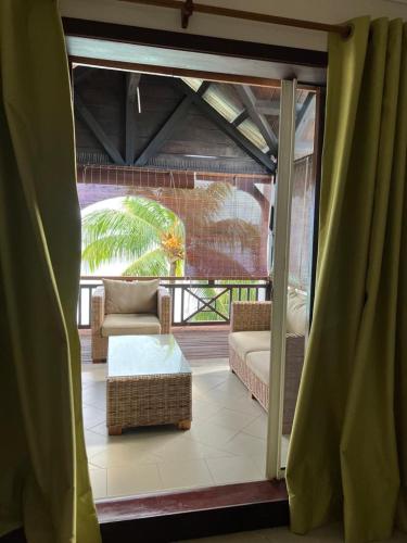 a screened in porch with a couch and a table at Sunset Boulevard, Grand Baie in Grand Baie