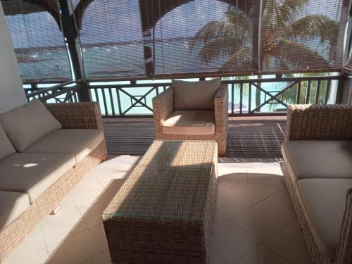 a balcony with two couches and a table and chairs at Sunset Boulevard, Grand Baie in Grand Baie