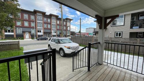 a porch with a car parked on a street at King and Queen rooms -J&J Chilliwack in Chilliwack