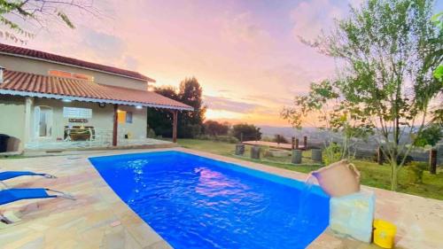 ein Pool vor einem Haus in der Unterkunft Casa de campo Bela Vista com Piscina na montanha in Piracaia
