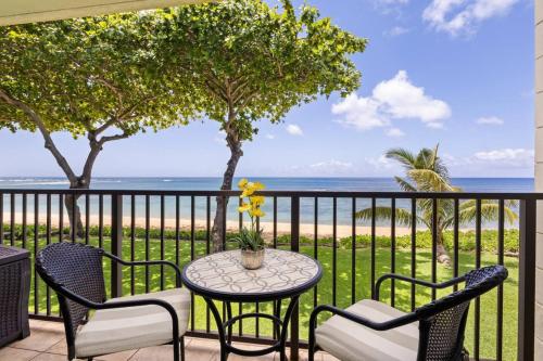 a patio with a table and chairs and the beach at Hidden Jewel in Haleiwa