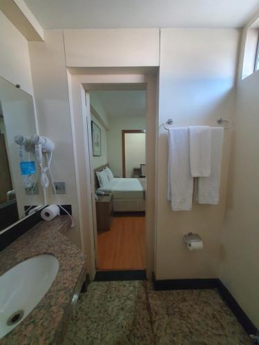 uma casa de banho com banheira e um quarto em Via Contorno Hotel em Belo Horizonte