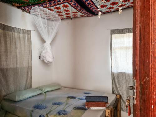 a bed in a room with a window at Sunny House Paje in Paje