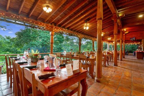 a restaurant with wooden tables and chairs with trees in the background at Ian Anderson Caves Branch Jungle Lodge in Belmopan