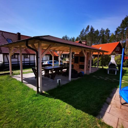 a pavilion with a picnic table in a yard at Domek na Gwizdówce nr.40 in Załakowo