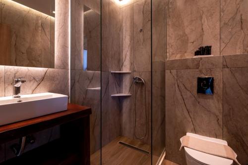 a bathroom with a sink and a shower at Bali Seaside Sailor in Bali