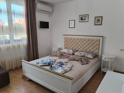 a bedroom with a large bed with a large window at Стаи за гости Гергана град Созопол in Sozopol